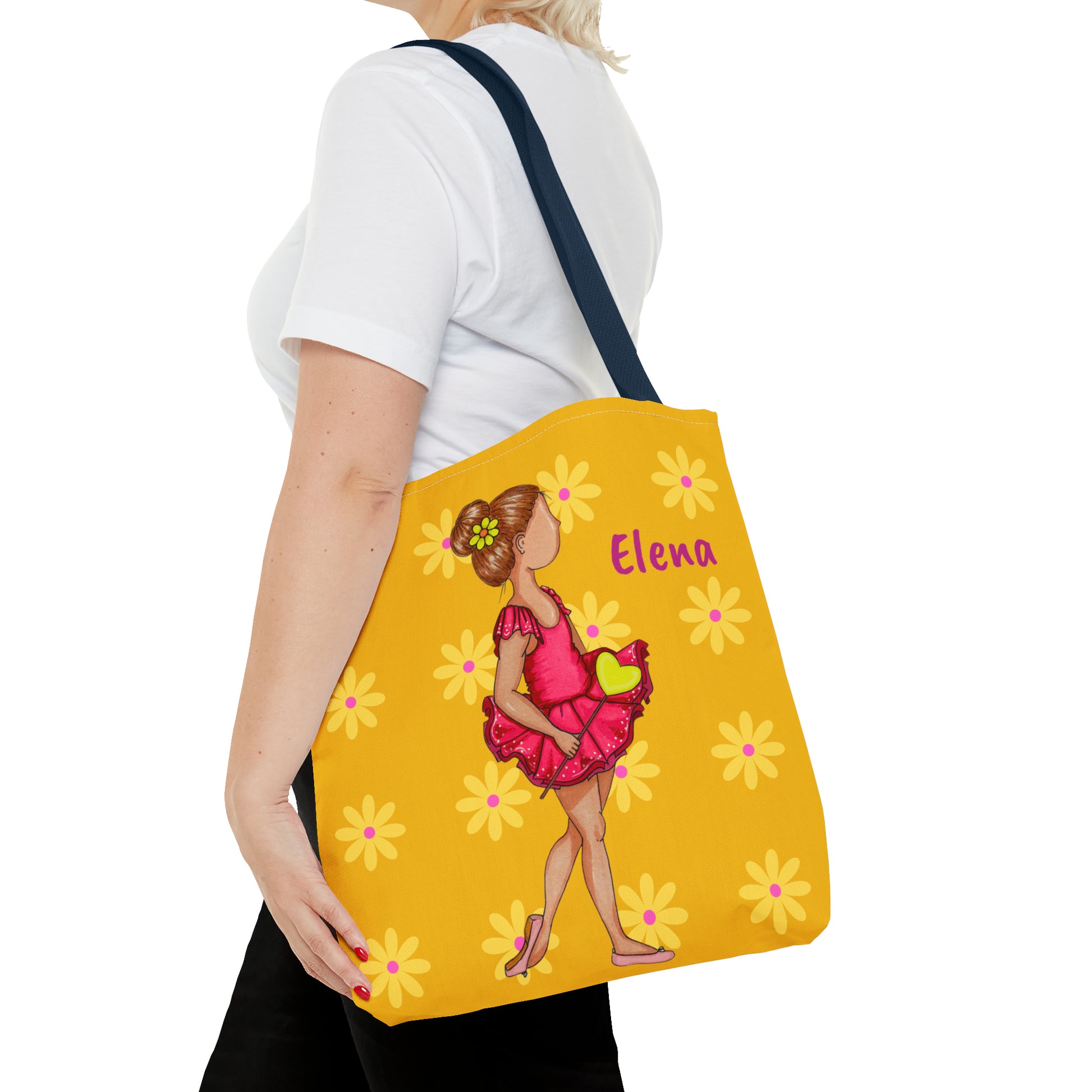 a woman carrying a yellow bag with a picture of a woman in a pink dress