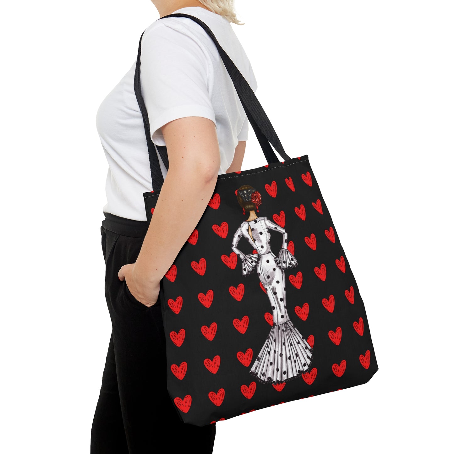 a woman carrying a black and red bag with hearts on it