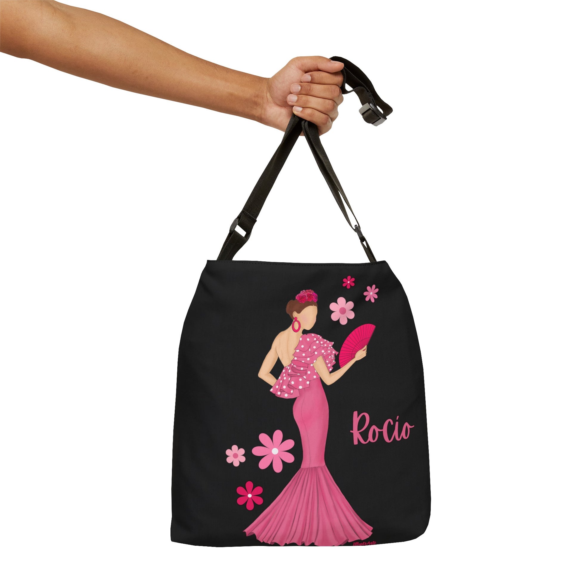 a hand holding a black bag with a woman in a pink dress