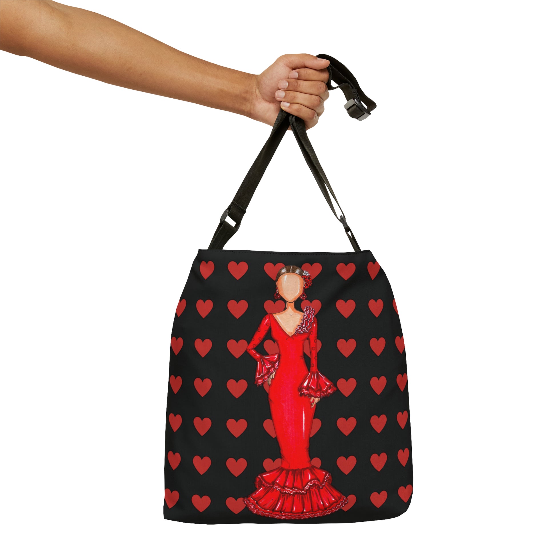 a woman's hand holding a black and red bag with hearts on it