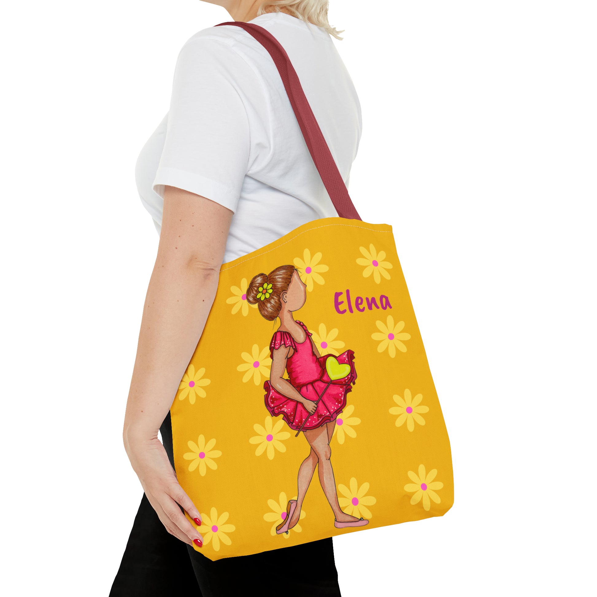 a woman carrying a yellow bag with a picture of a woman in a pink dress