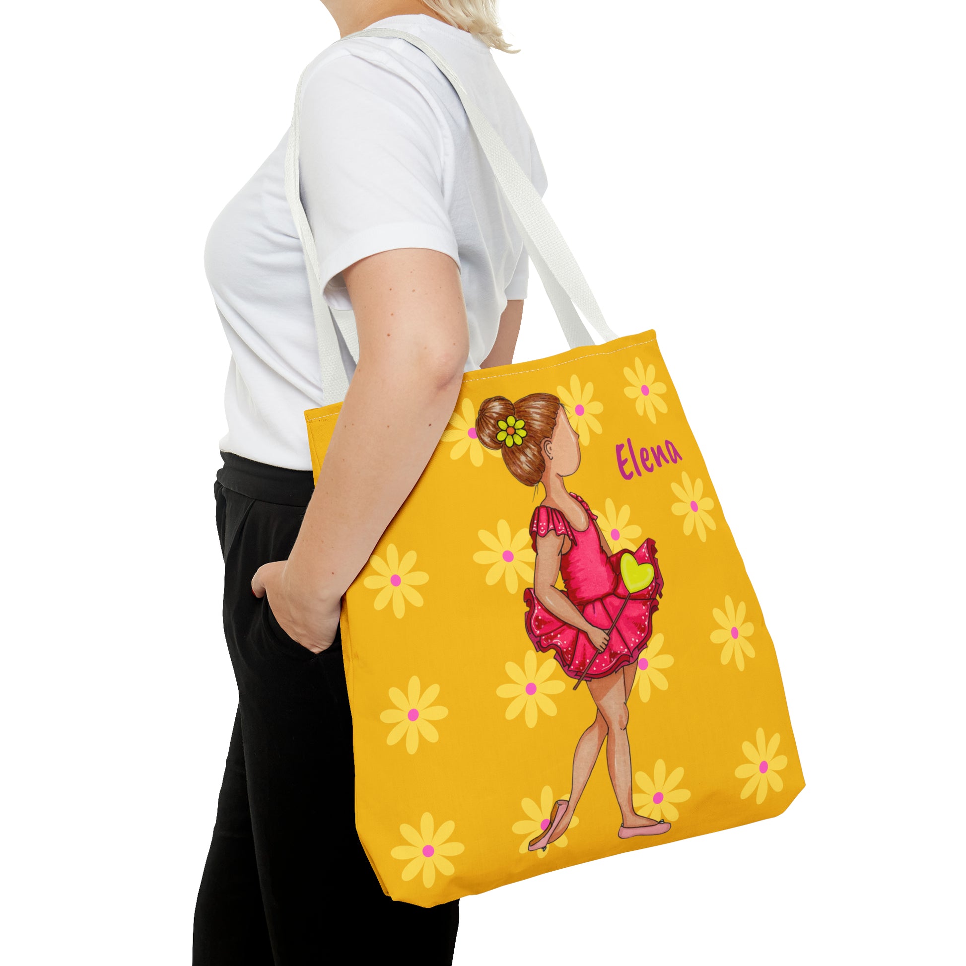 a woman carrying a yellow bag with a picture of a girl on it