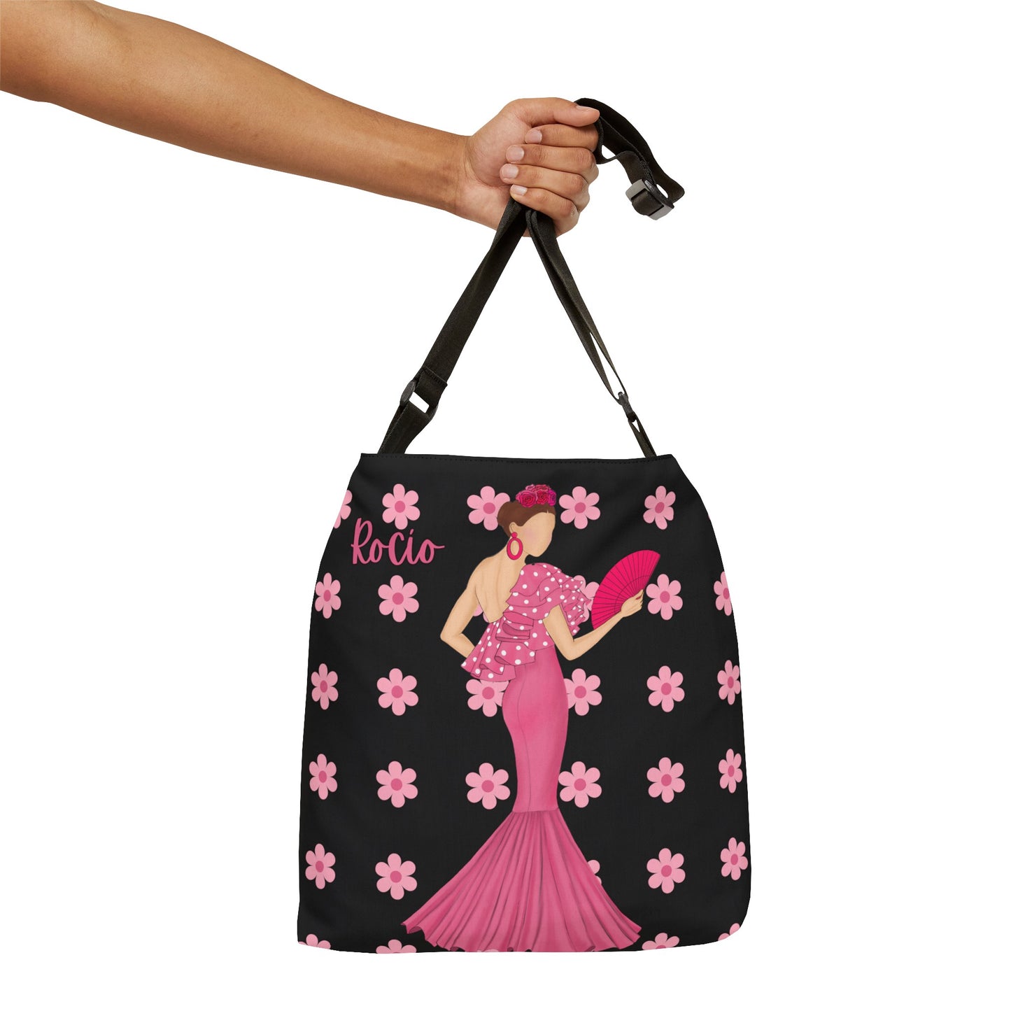 a hand holding a black and pink purse