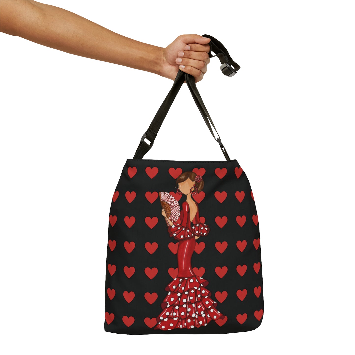 a hand holding a black and red bag with hearts on it