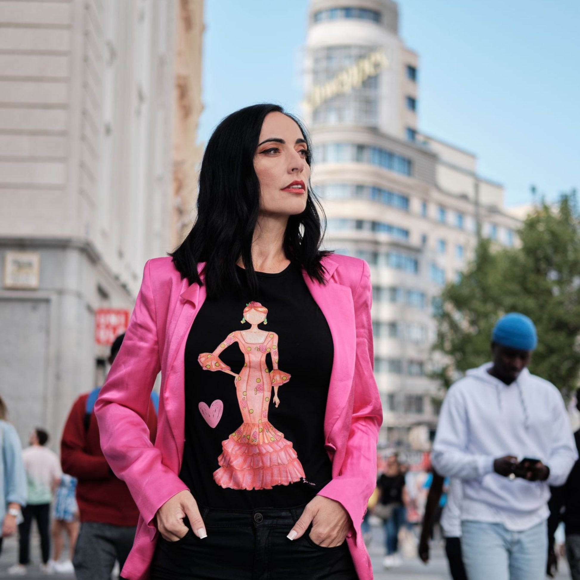 a woman in a black shirt and pink jacket