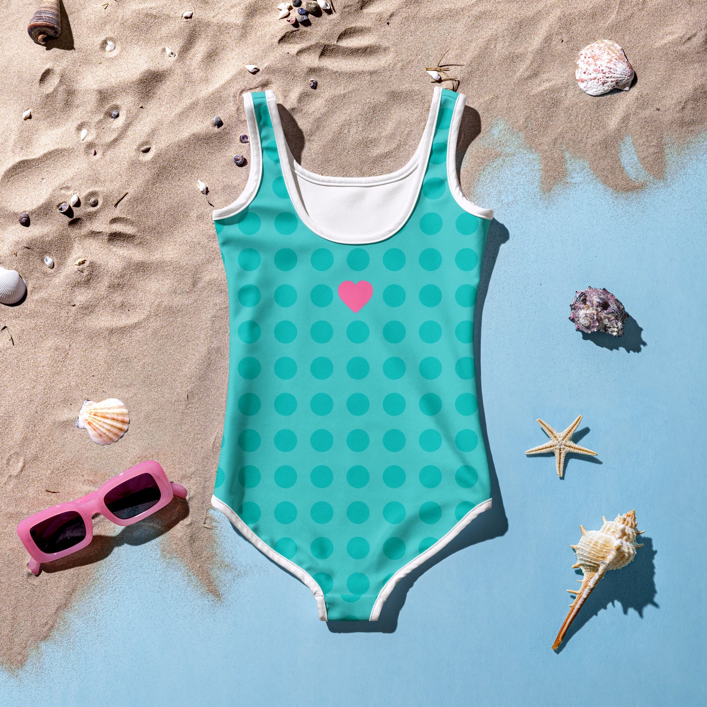 a bathing suit, sunglasses, starfish, and seashells on a beach