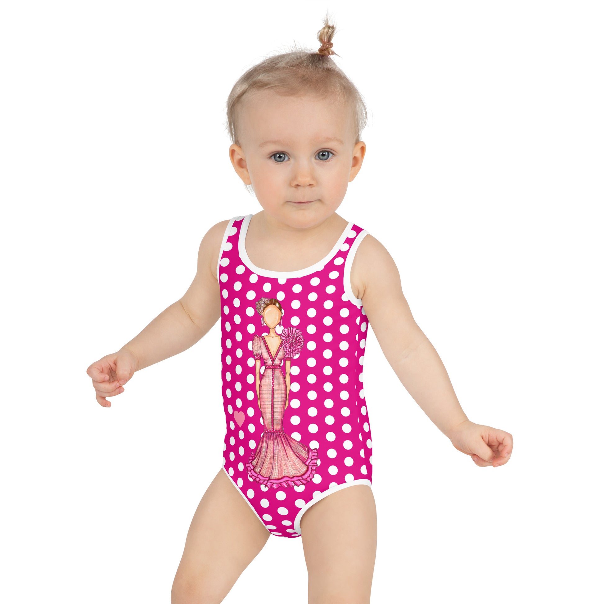 a baby girl wearing a pink and white polka dot swimsuit
