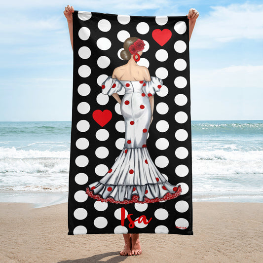 a woman standing on a beach holding a polka dot towel
