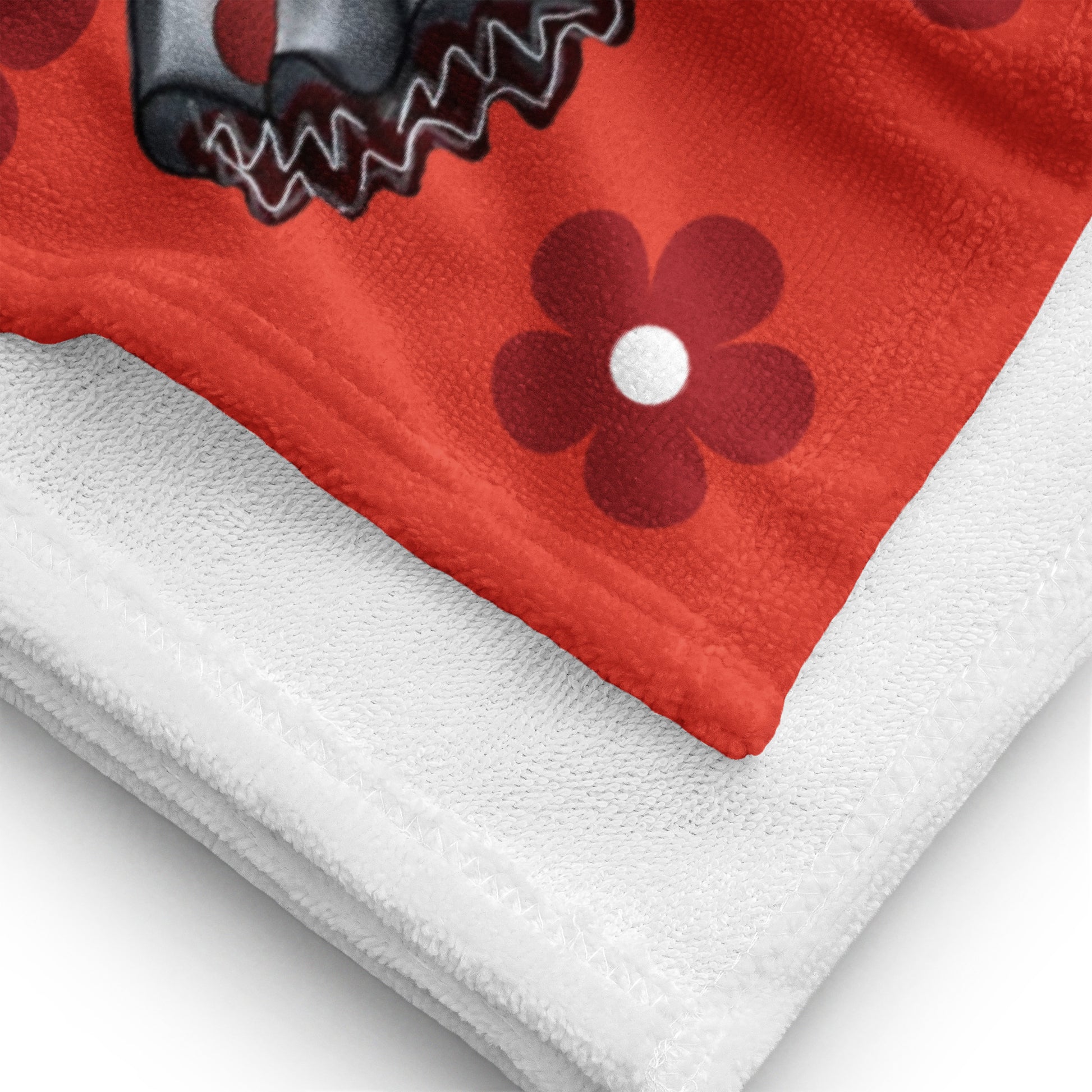 a red and white towel with a black flower on it