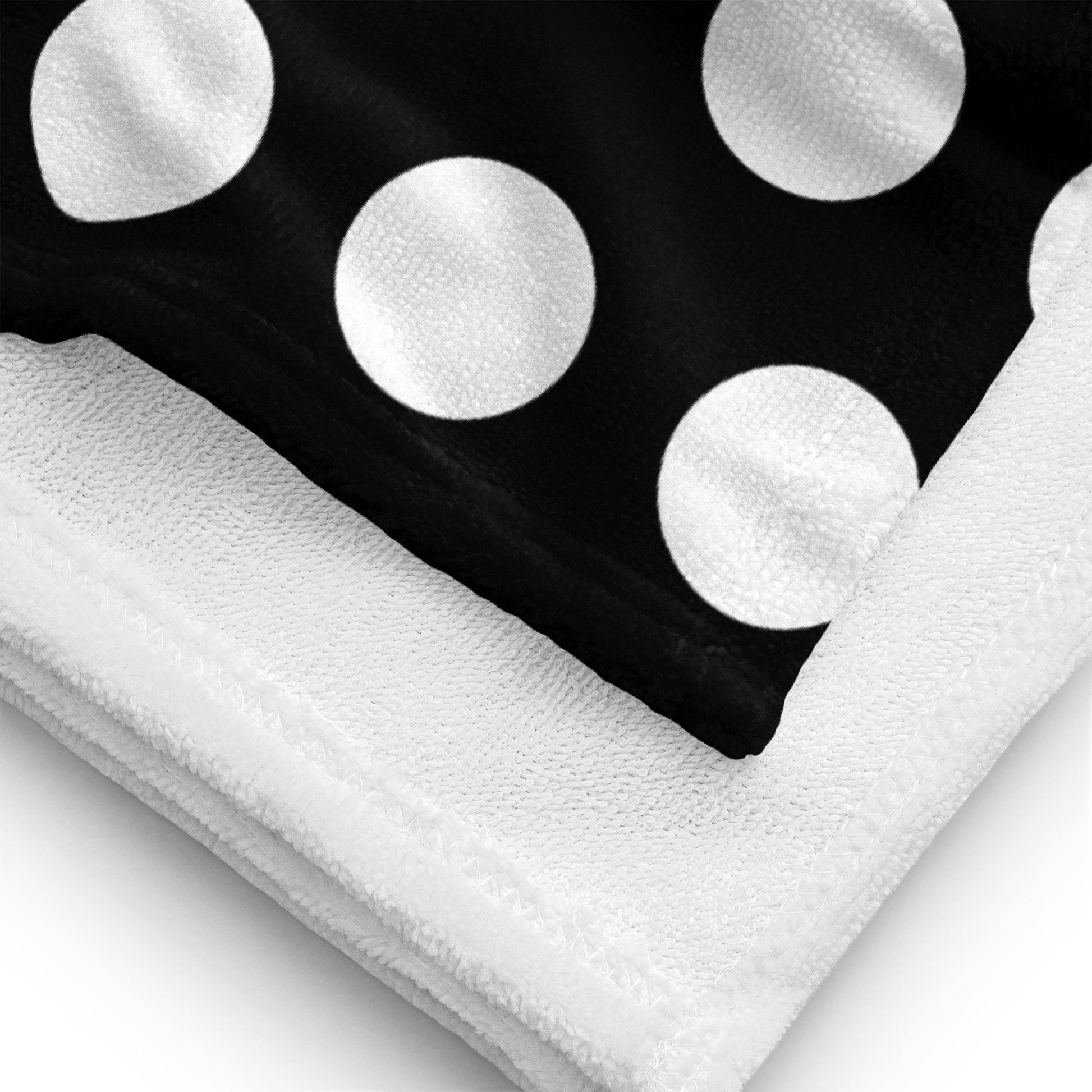 a black and white polka dot towel on top of a white towel
