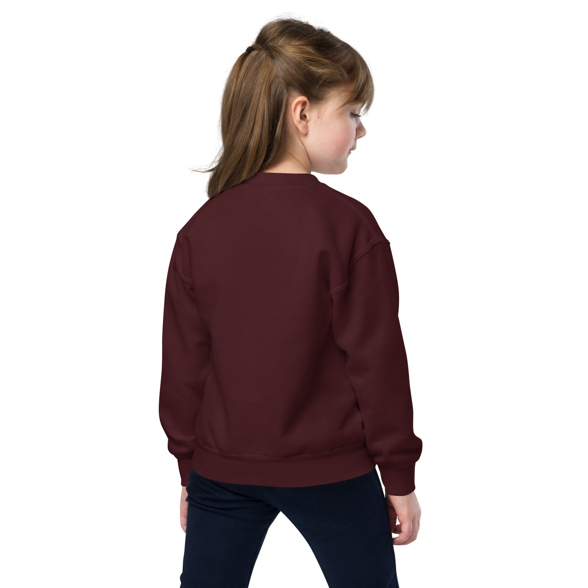 a young girl wearing a maroon sweatshirt and black pants