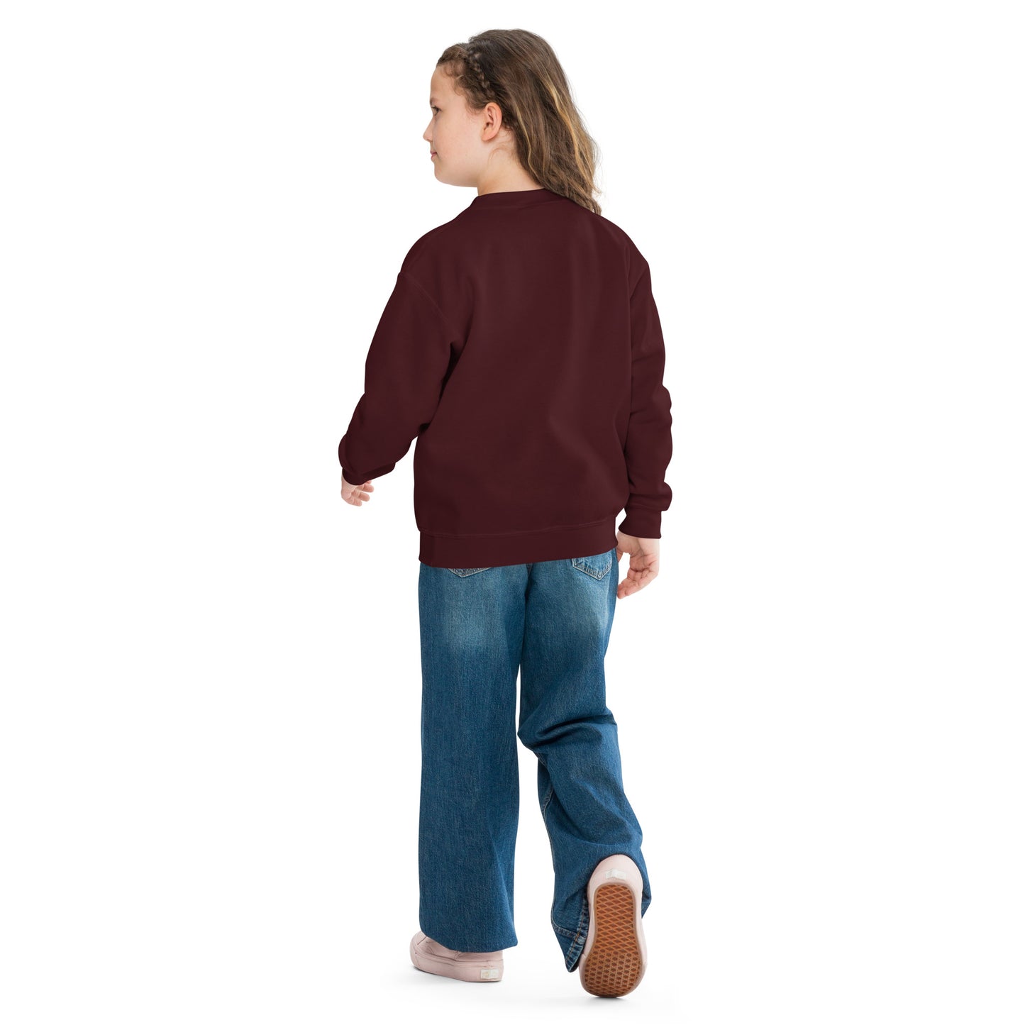 a little girl wearing a maroon sweatshirt and jeans